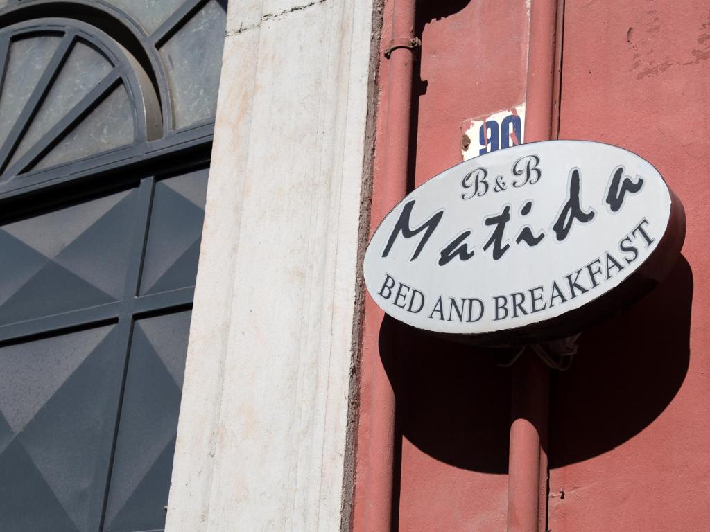 una señal para un restaurante al lado de un edificio en B&B Matida, en Torre Annunziata