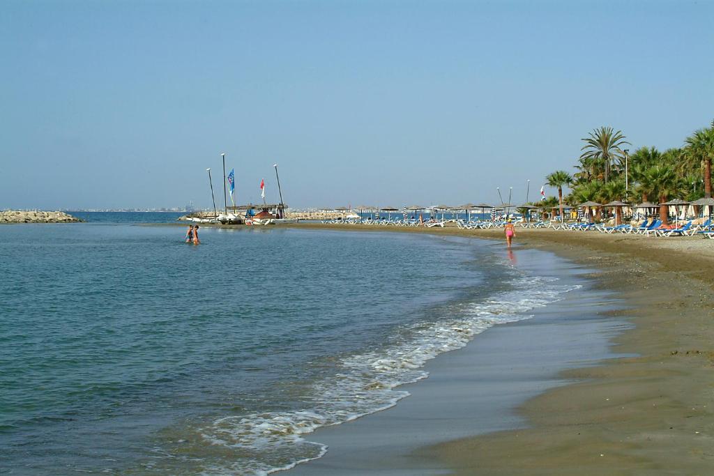 einen Strand mit einer Gruppe von Stühlen und dem Meer in der Unterkunft Sunbay Apartments in Pyla