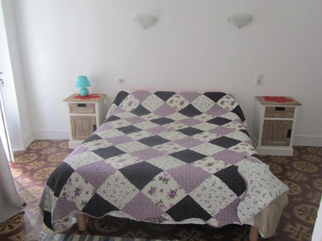 a quilt on a bed in a room at Chez Tania in Vallon-Pont-dʼArc