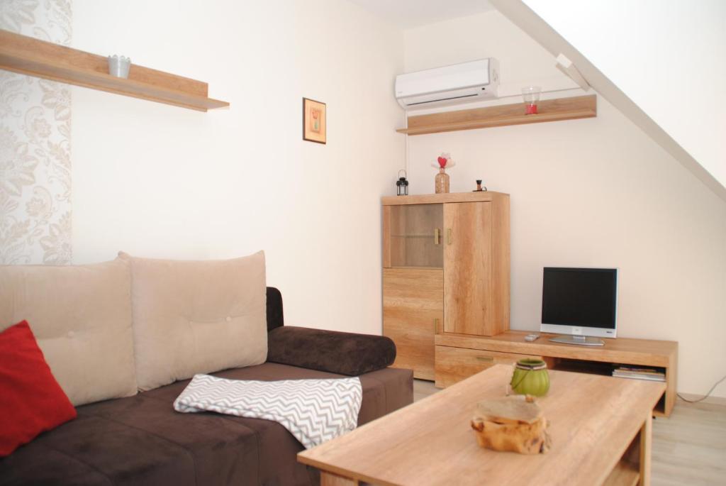 ein Wohnzimmer mit einem Sofa und einem Tisch in der Unterkunft Szamóca Apartman in Szeged
