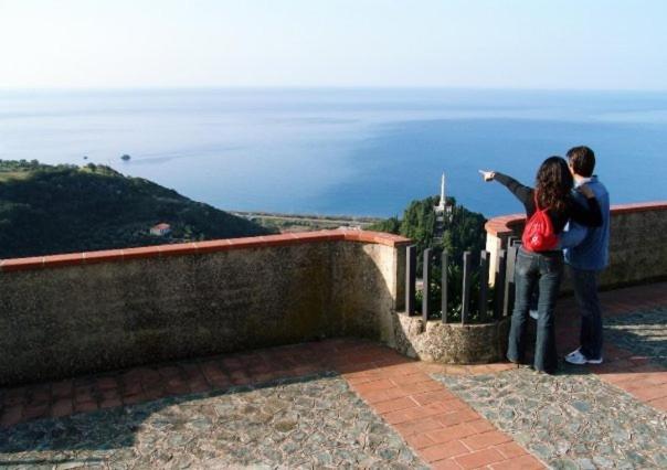 zwei Menschen stehen auf einem Felsvorsprung und sehen auf den Ozean in der Unterkunft A Taverna Intru U Vicu in Belmonte Calabro