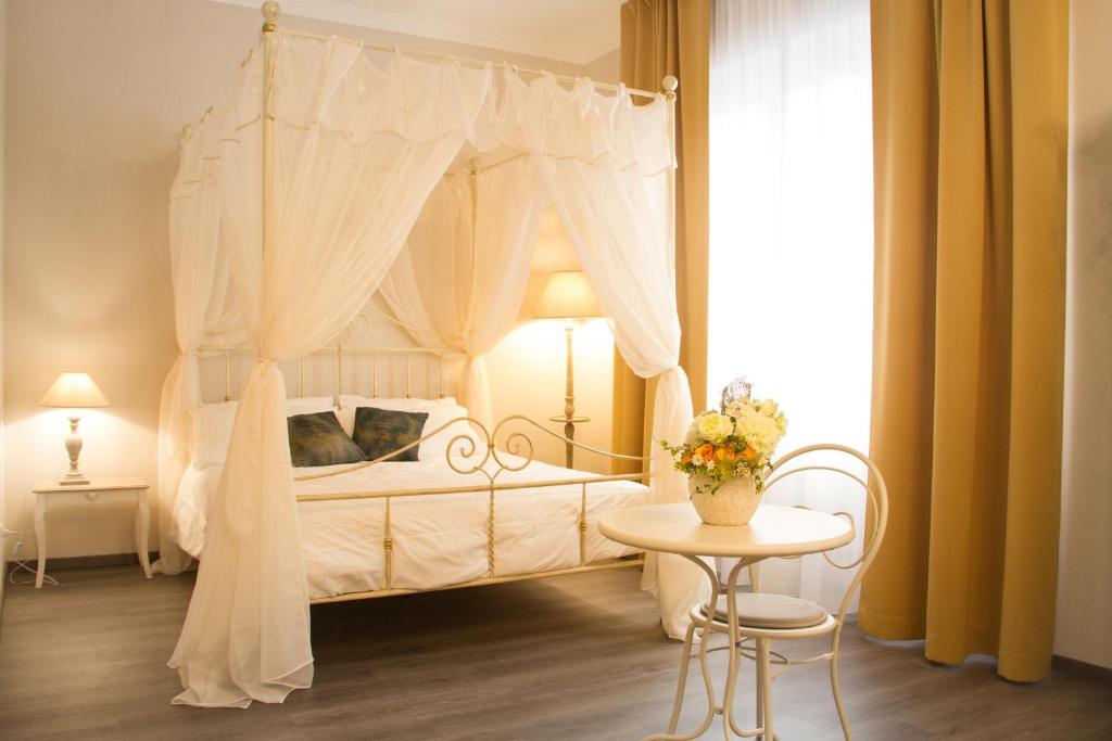 una camera con un letto a baldacchino bianco e un tavolo di Cà do Franco a Chiavari