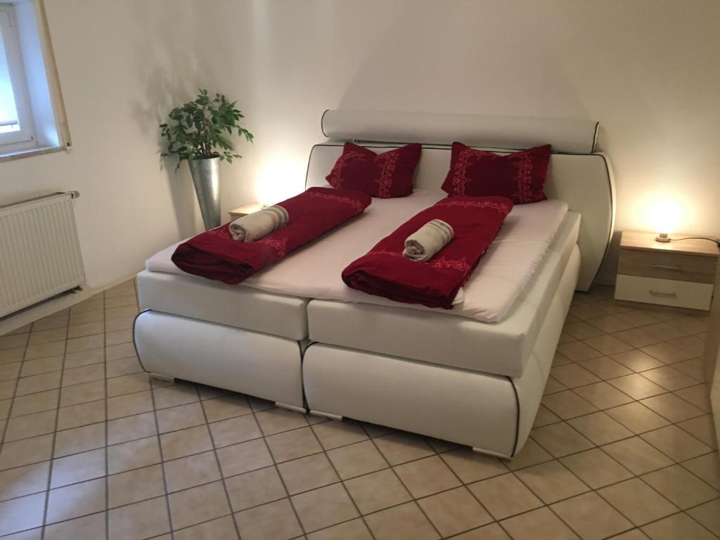 een witte bank met rode kussens op een kamer bij Apartment Germersheim in Germersheim