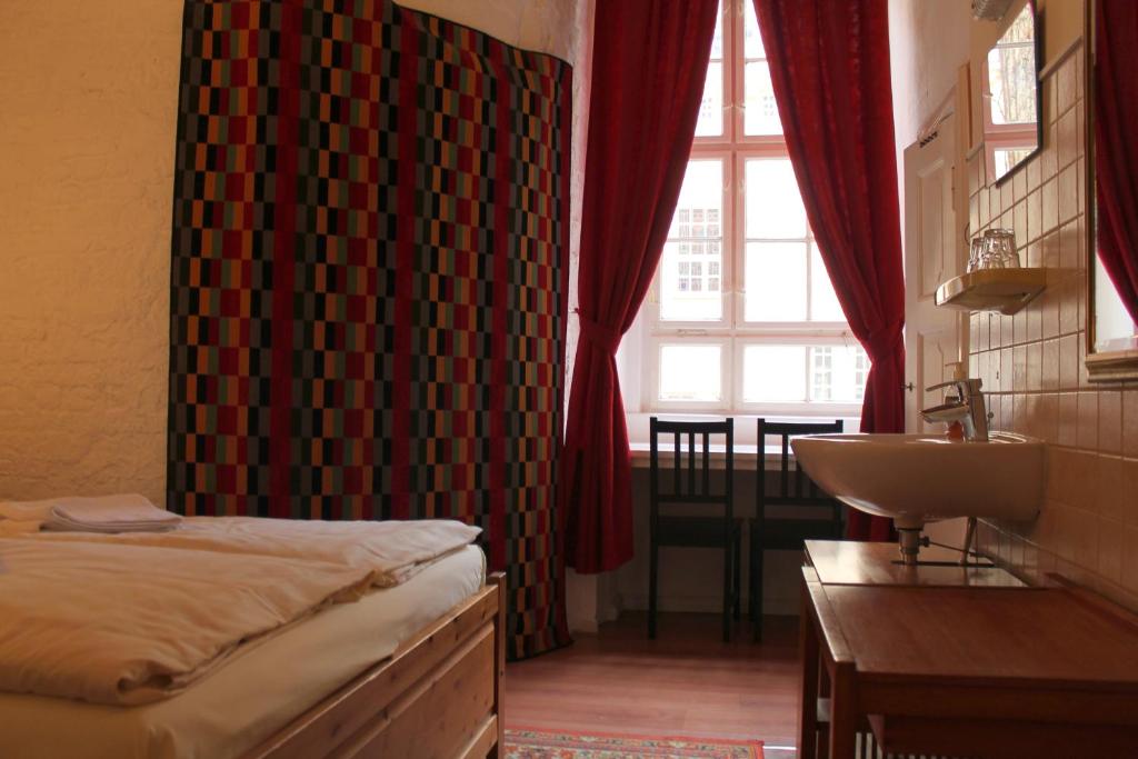 ein Schlafzimmer mit einem Bett, einem Waschbecken und einem Fenster in der Unterkunft Hotel Pension Waizenegger am Kurfürstendamm in Berlin