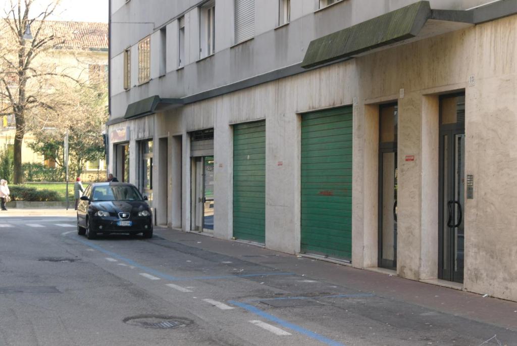 samochód zaparkowany przed budynkiem z zielonymi drzwiami garażowymi w obiekcie Apartment Podgora 13 w Mestre