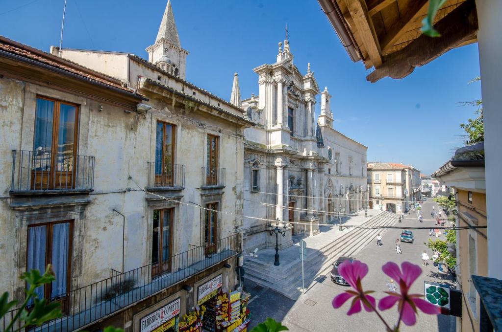 スルモーナにあるSantacroce Guesthouse Abruzzoの紫の花が咲くバルコニー付きの古い建物