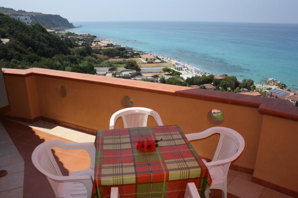 a table and chairs on a balcony with a view of the ocean at Casa fiorina a Capo vaticano in Capo Vaticano