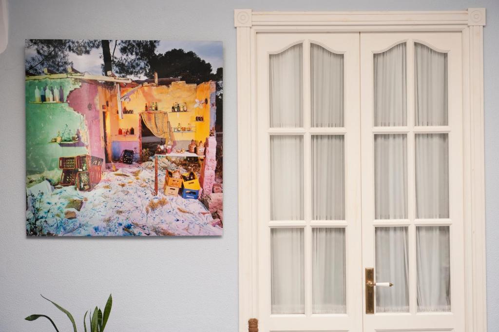 a white door next to a painting on a wall at Casa Patio del Panadero in Cádiz