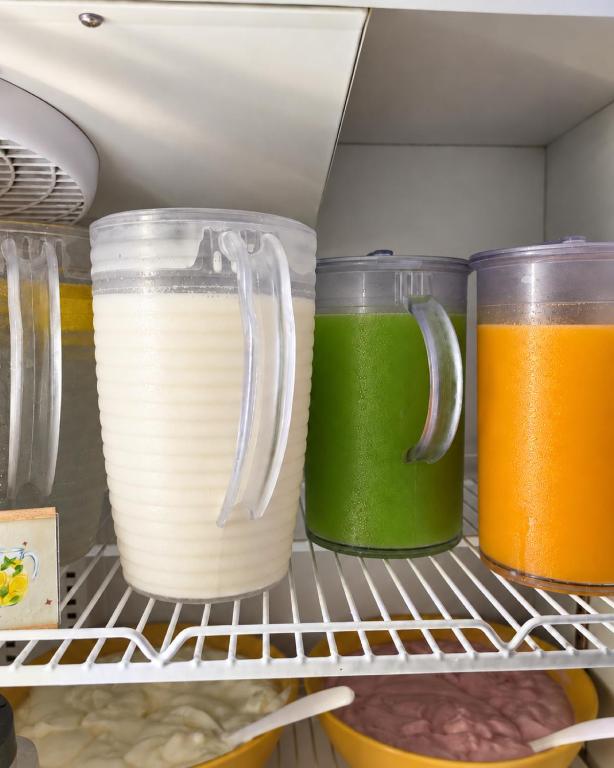 A refrigerated drinks and chilled-food station with three colourful pitchers.
