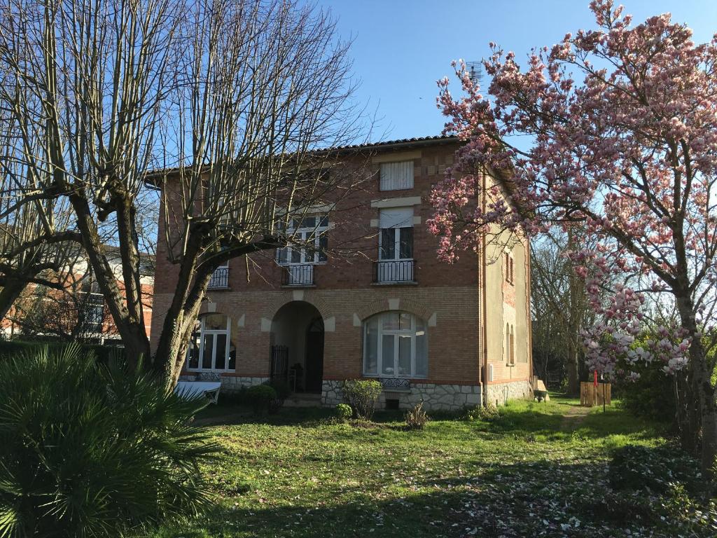 a brick house with trees in front of it at Chez Dan et Véro - Chambre d'hôte in Moissac