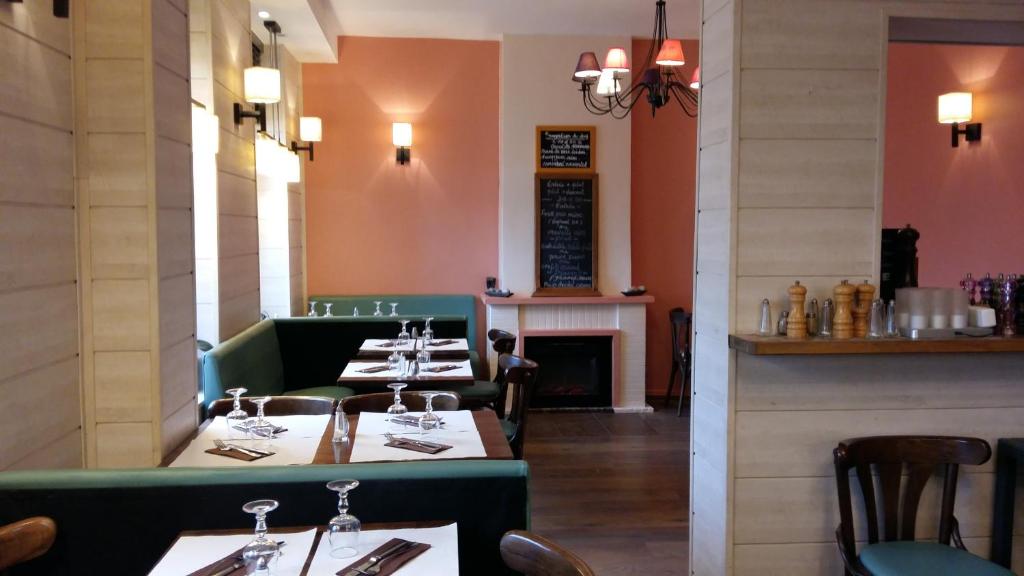 a dining room with tables and chairs and a fireplace at Les Galets Bleus in Étretat