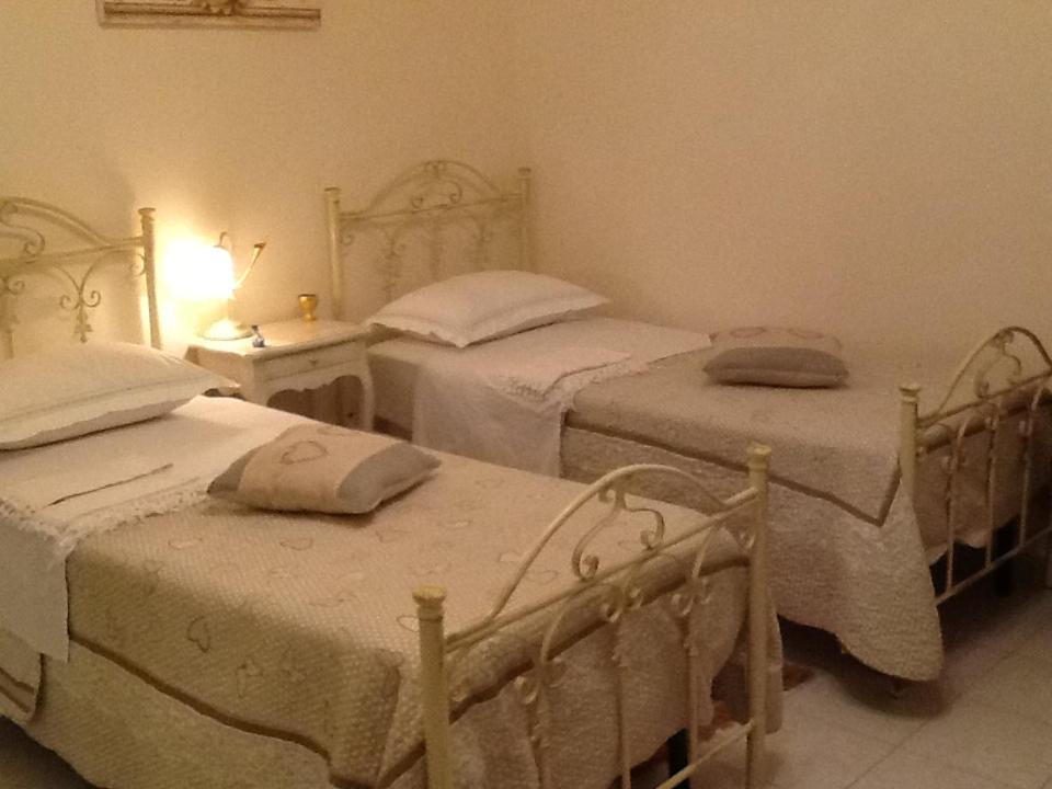 ein Schlafzimmer mit 2 Betten und einem Tisch mit einer Lampe in der Unterkunft B&B Paradiso San Vincenzo in Molfetta