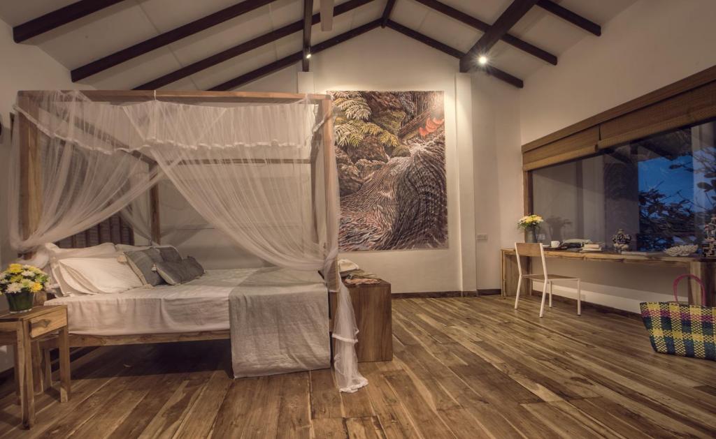 a bedroom with a canopy bed and a desk at C Beyond Nilaveli in Nilaveli