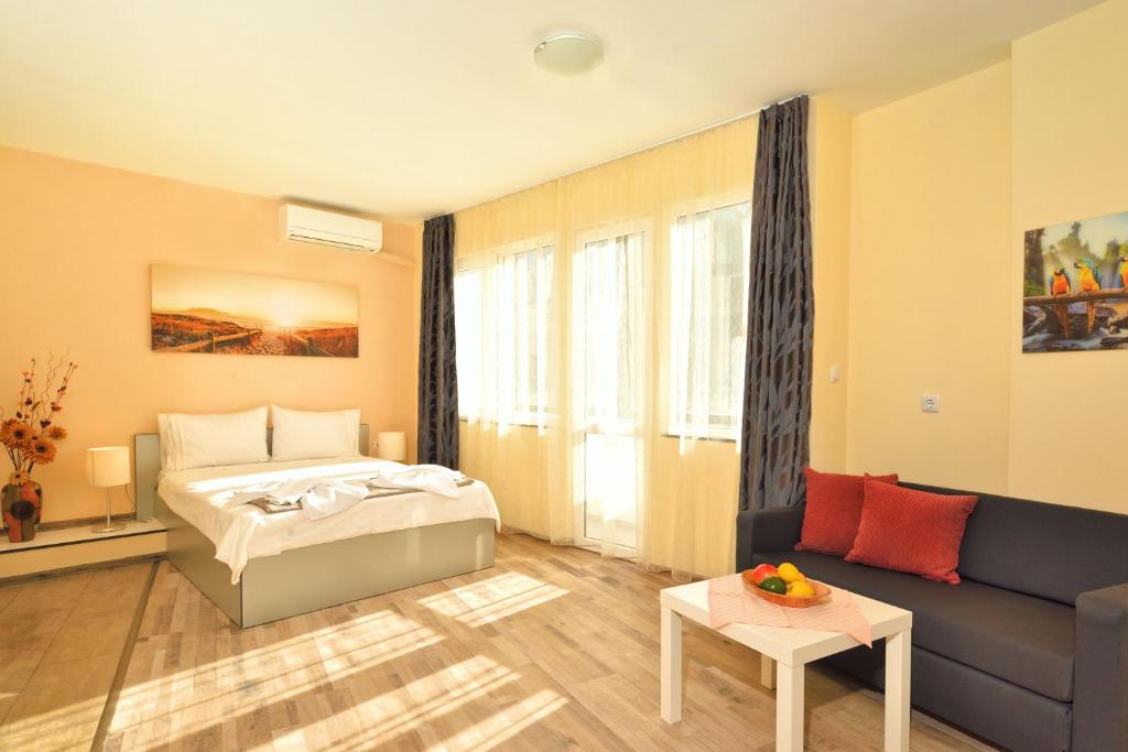 a hotel room with a bed and a couch at Central studio #3 in Burgas