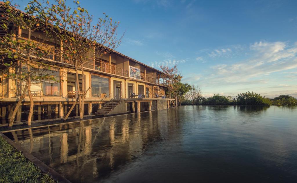 a building on the side of a river at C Beyond Nilaveli in Nilaveli
