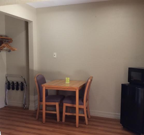 a wooden table and chairs in a room at Stratford House Inn and Suites Temple in Temple