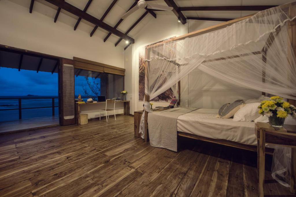 a bedroom with a canopy bed with a view of the ocean at C Beyond Nilaveli in Nilaveli