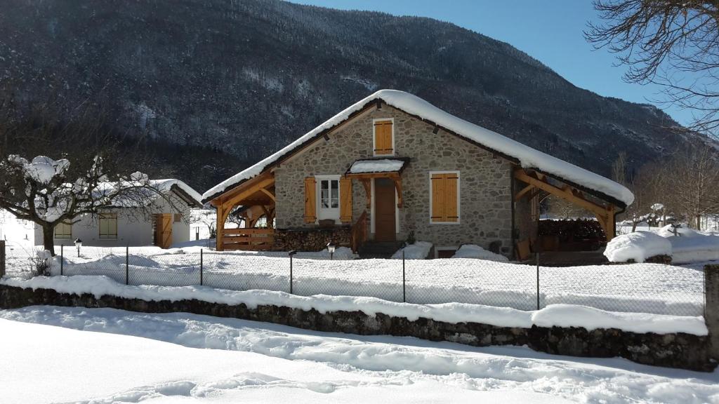 a house covered in snow in front of a mountain at Ouxis in Orlu