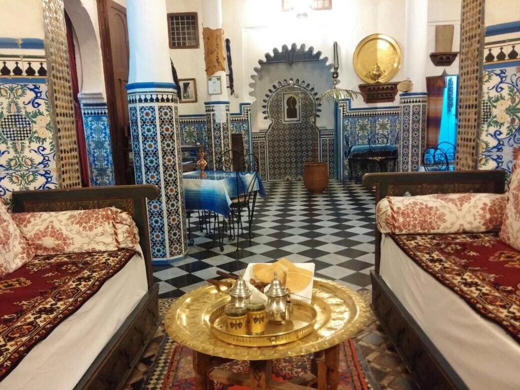 een kamer met twee bedden en een tafel erin bij Hotel Riad Dalia Tetouan in Tetouan