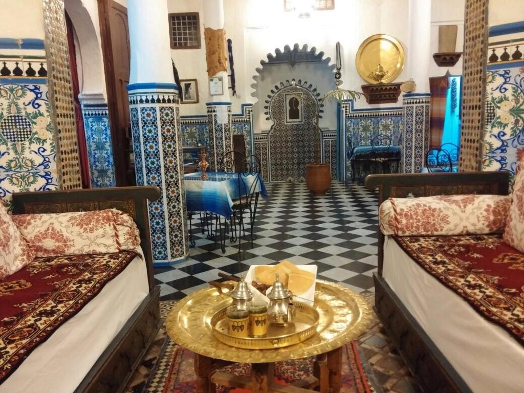 Habitación con 2 camas y mesa. en Hotel Riad Dalia Tetouan en Tetuán