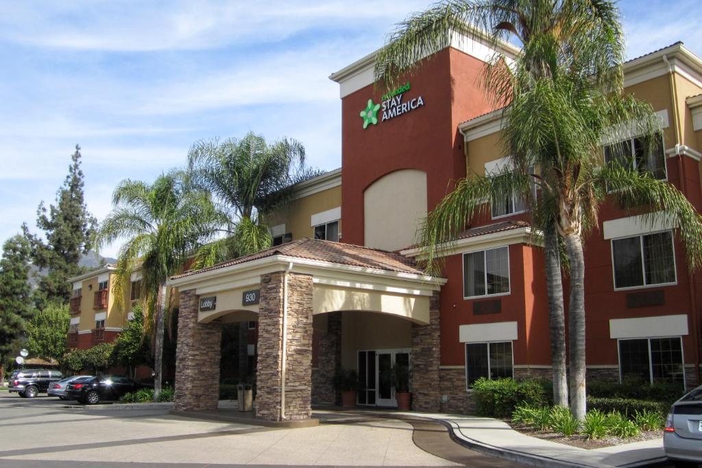 a hotel building with palm trees in front of it at Extended Stay America Suites - Los Angeles - Monrovia in Monrovia