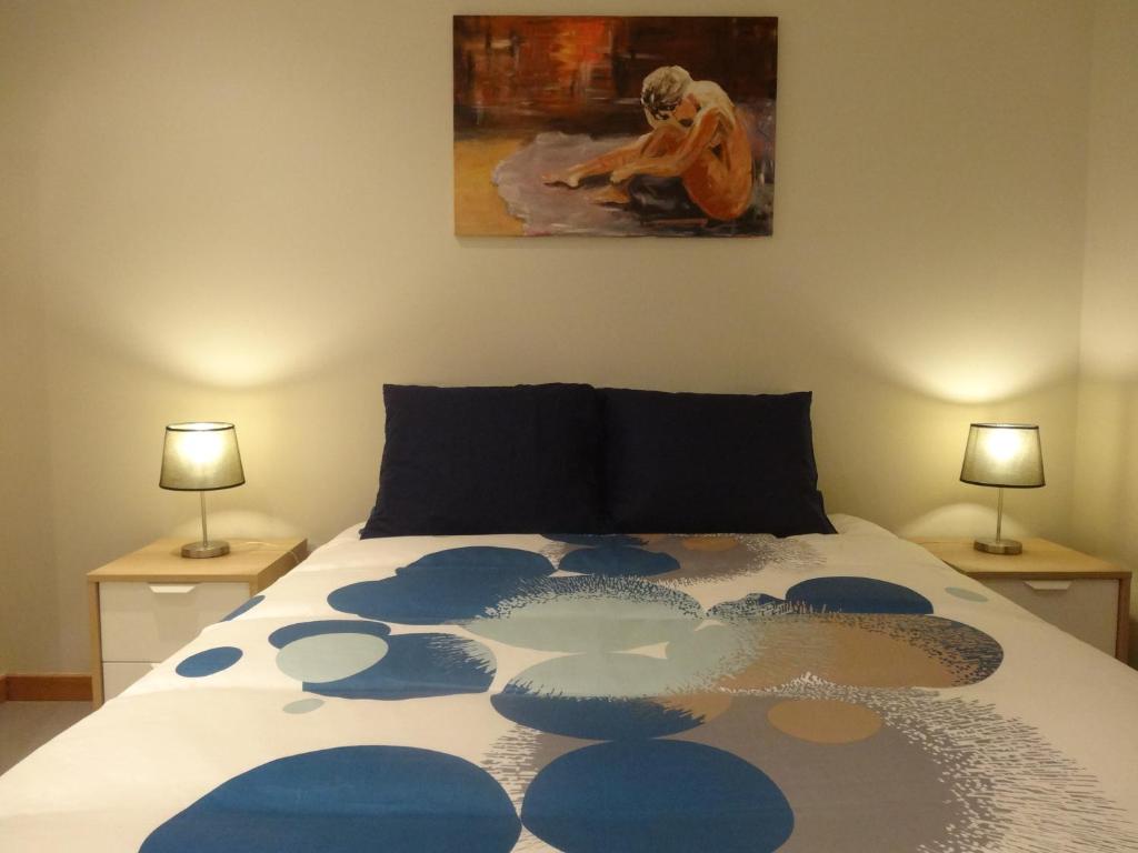een slaapkamer met een bed met een schilderij aan de muur bij Casa em Aldeia Pescadores in Vila Nova de Gaia