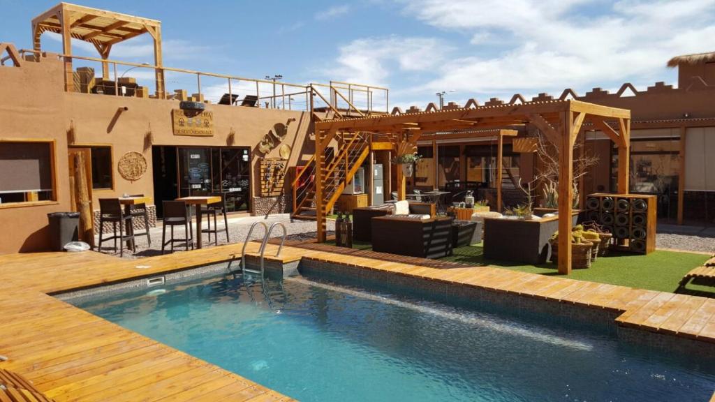 a swimming pool with a pool table and chairs at Hoteles Pueblo de Tierra in San Pedro de Atacama