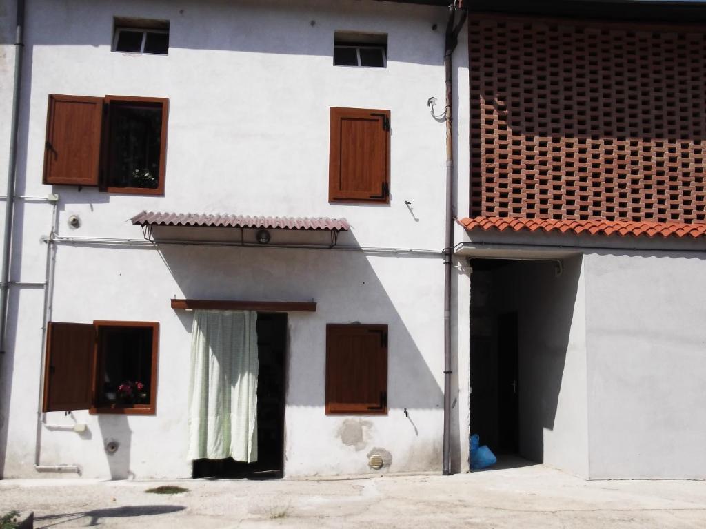 un edificio blanco con ventanas marrones y una puerta en La Panoramica, en Perarolo