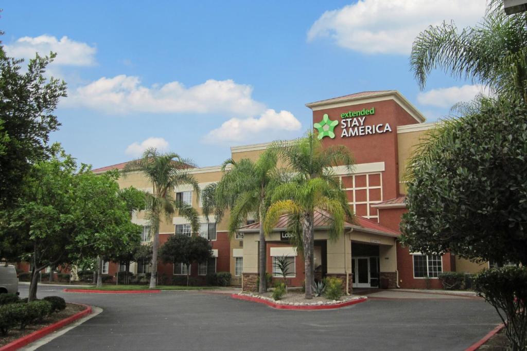 a front view of a hotel with a parking lot at Extended Stay America Suites - Orange County - Cypress in Cypress