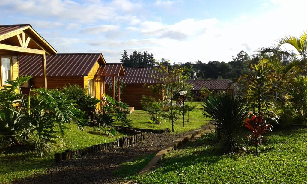 a house in a yard with trees and plants at Cabañas Doralia in Oberá