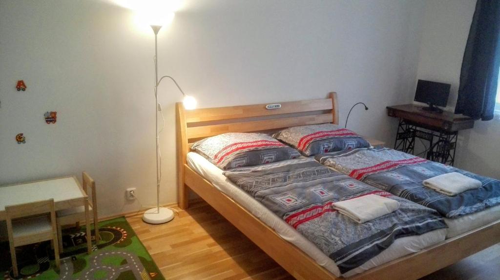 a bedroom with a wooden bed with two pillows at Jezerka Apartments in Prague