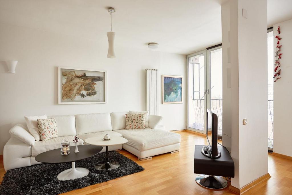 un soggiorno con divano bianco e tavolo di Luxury Apartment Near City Center a Skopje