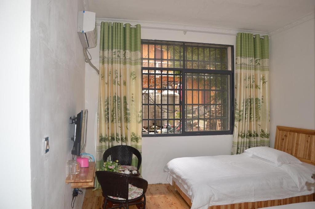 a bedroom with a bed and a window at Yangjiajie Inn in Zhangjiajie