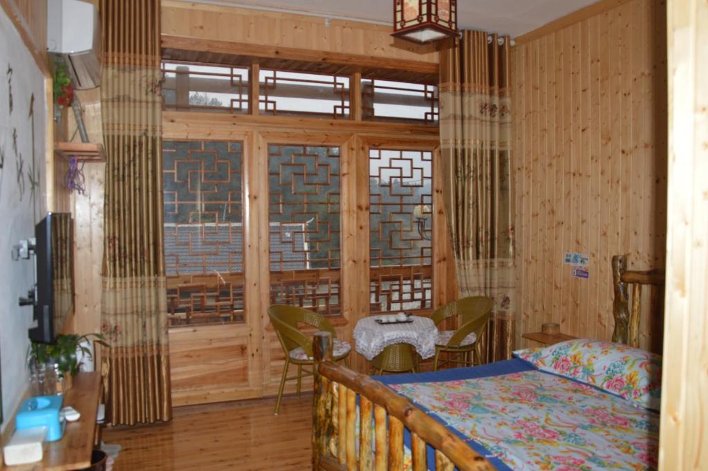 a bedroom with a bed and a large window at Yangjiajie Inn in Zhangjiajie