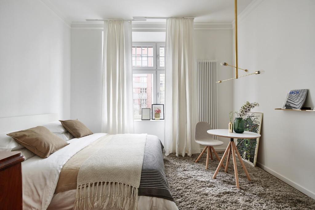 a bedroom with a bed and a table and a window at FOUR STORIES APARTMENTS - Krasinskiego in Kraków