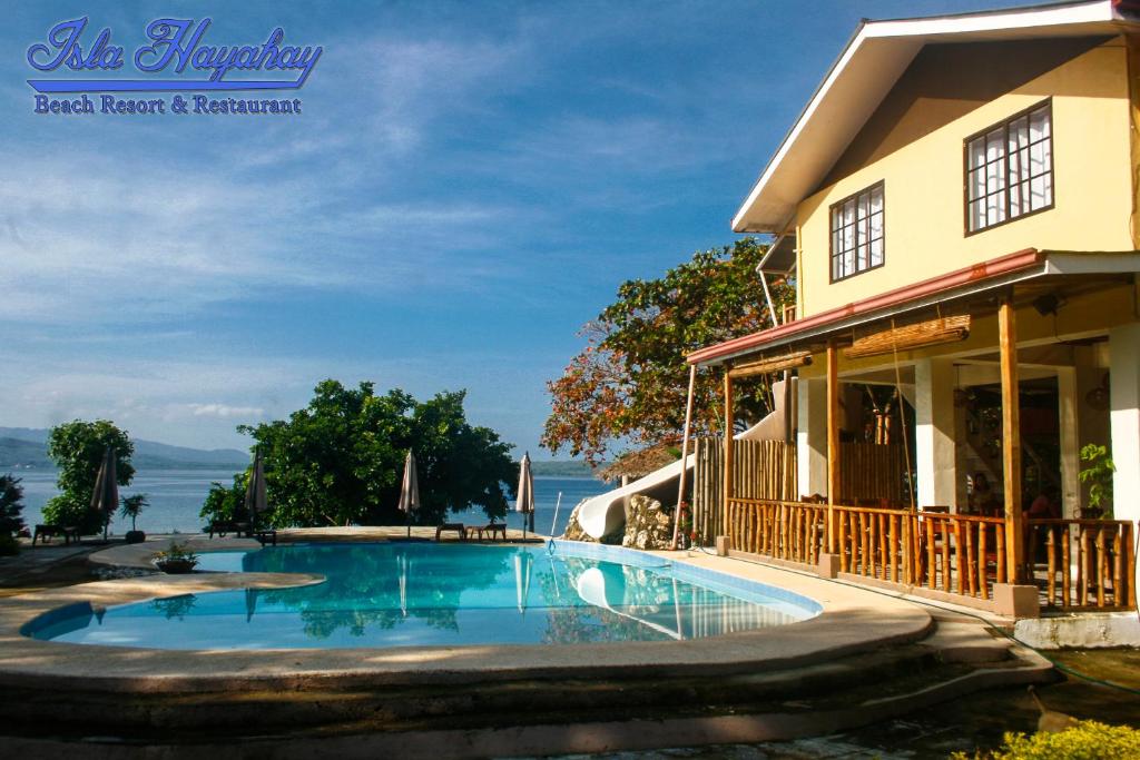 a swimming pool in front of a house at Isla Hayahay Beach Resort and Restaurant in Calape