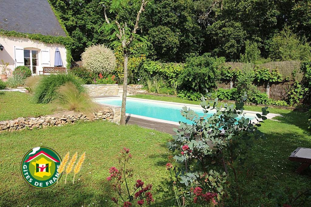einen Hof mit einem Pool und einem Haus in der Unterkunft Logis du Lièvre d'or in Montbazon