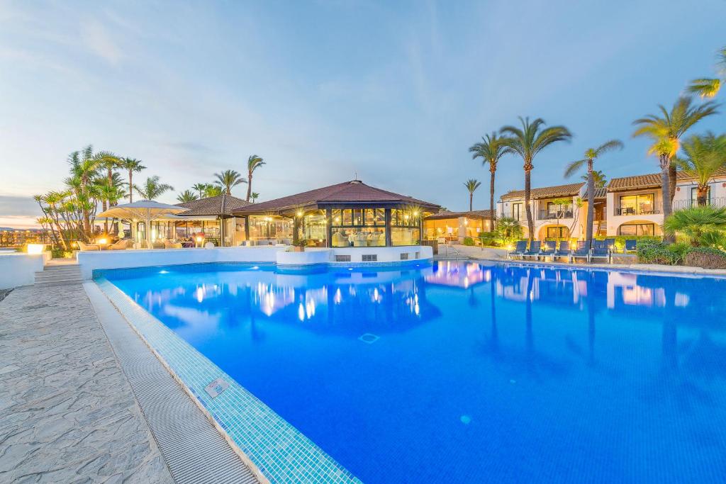 a large blue swimming pool in front of a building at Botel Alcudiamar in Port d'Alcudia