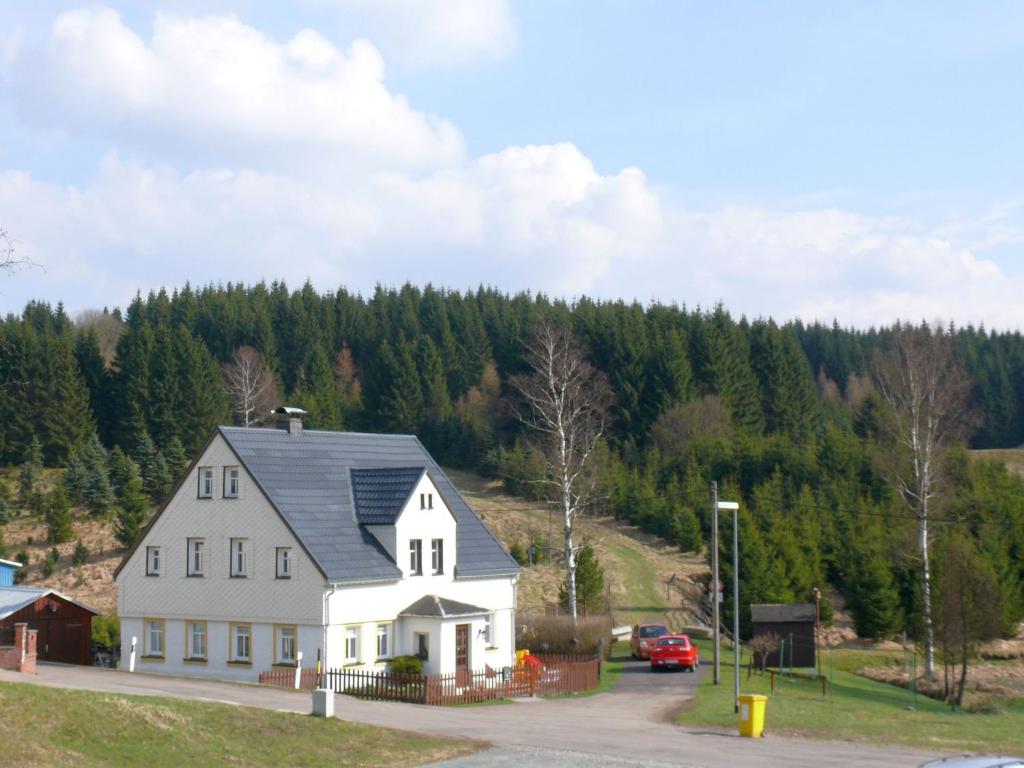 a white house with a gray roof on a hill at Feriendomizil Erzgebirge in Marienberg