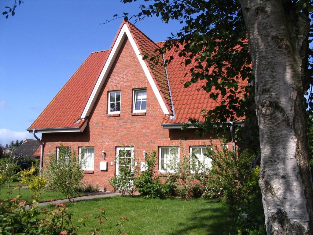 ein rotes Backsteinhaus mit rotem Dach in der Unterkunft Im Land der Horizonte in Seeth