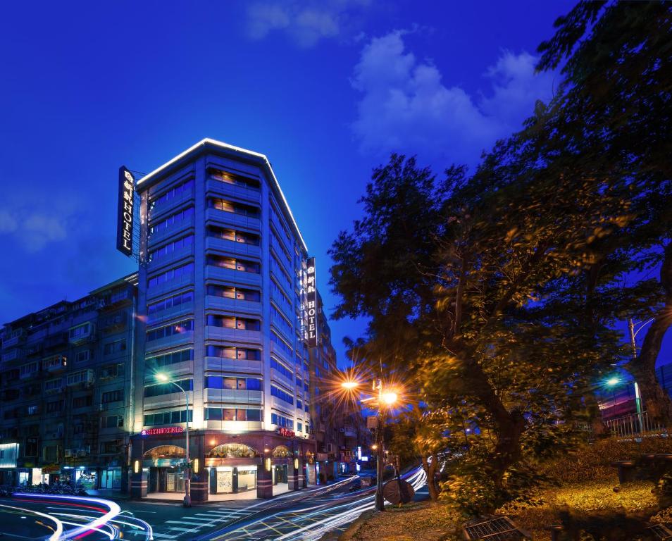 a tall building on a city street at night at Silken Hotel in Taipei