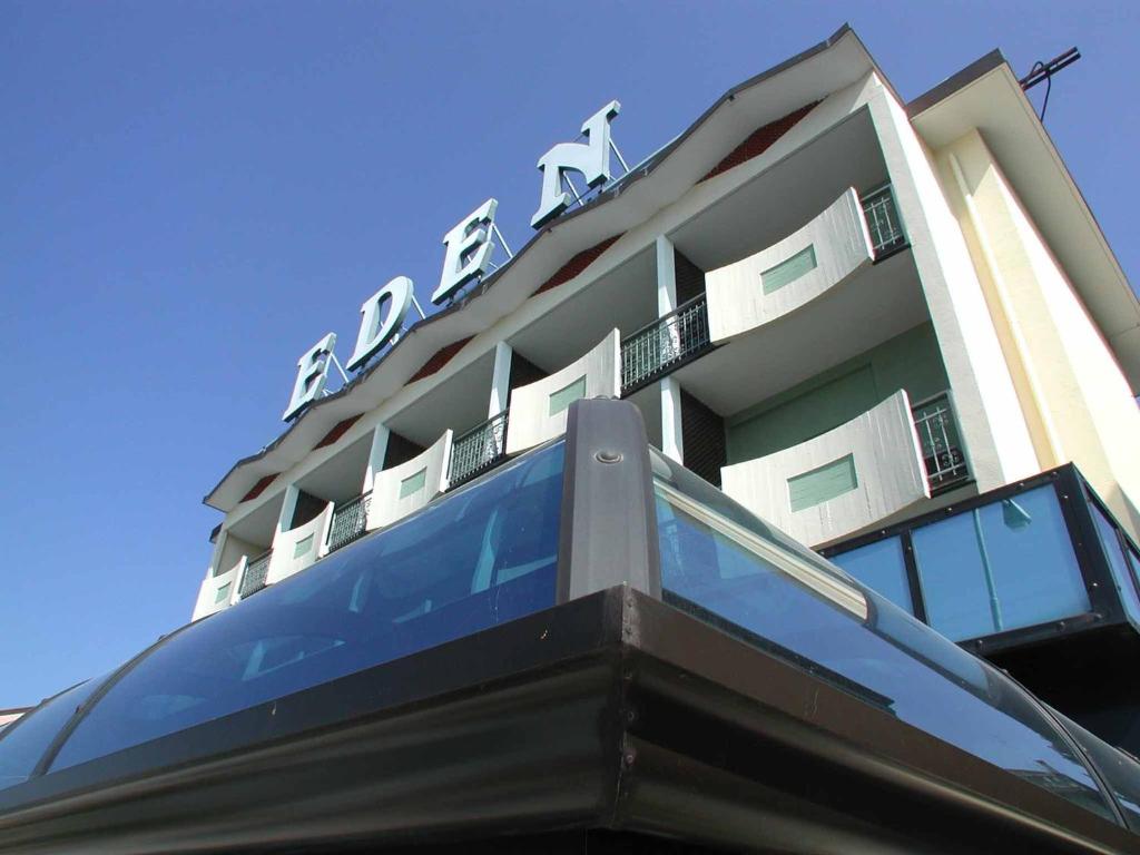 a building with a sign on top of it at Hotel Eden in Grado