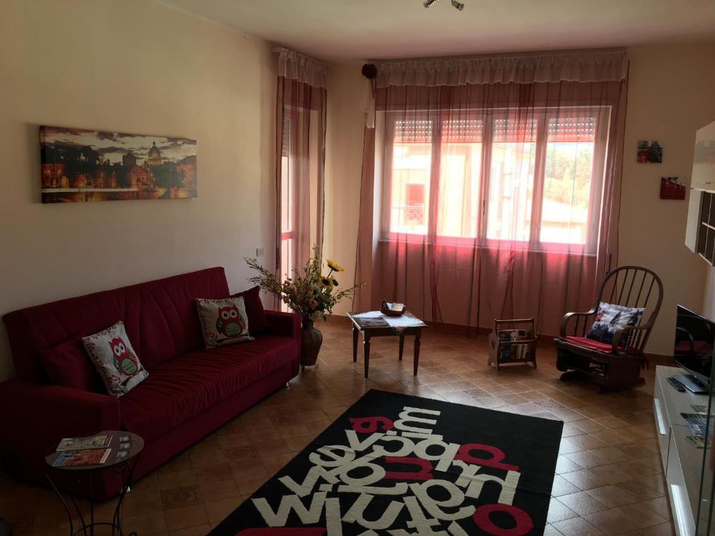 sala de estar con sofá rojo y alfombra en Big Family, en Ariccia