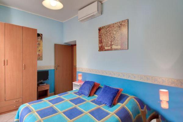 ローマにあるLa Dolce Vita Colosseumのベッドルーム1室(青いベッド1台、青い枕2つ付)