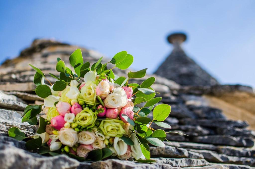 a bouquet of flowers on the top of a building at Trullo in Light in Alberobello