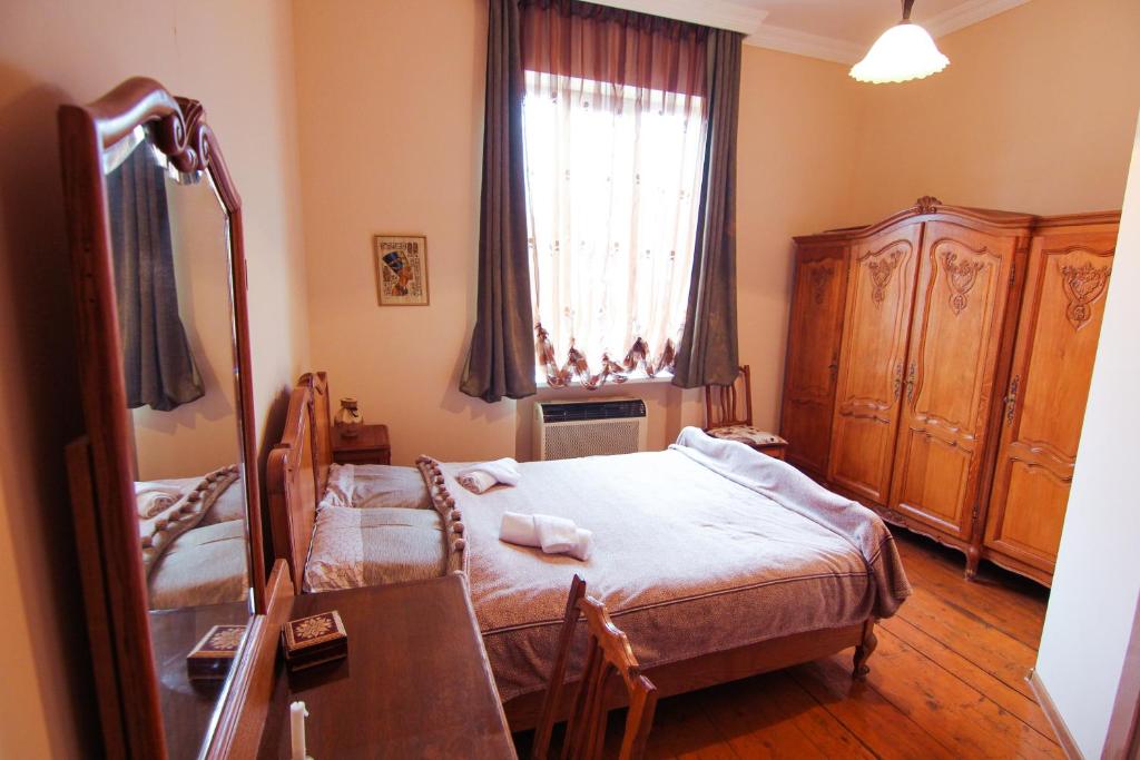 a bedroom with a bed and a desk and a window at Tamari Guest House in Tʼelavi