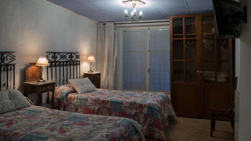 een hotelkamer met 2 bedden en een raam bij Hostal los Aromas in Villena