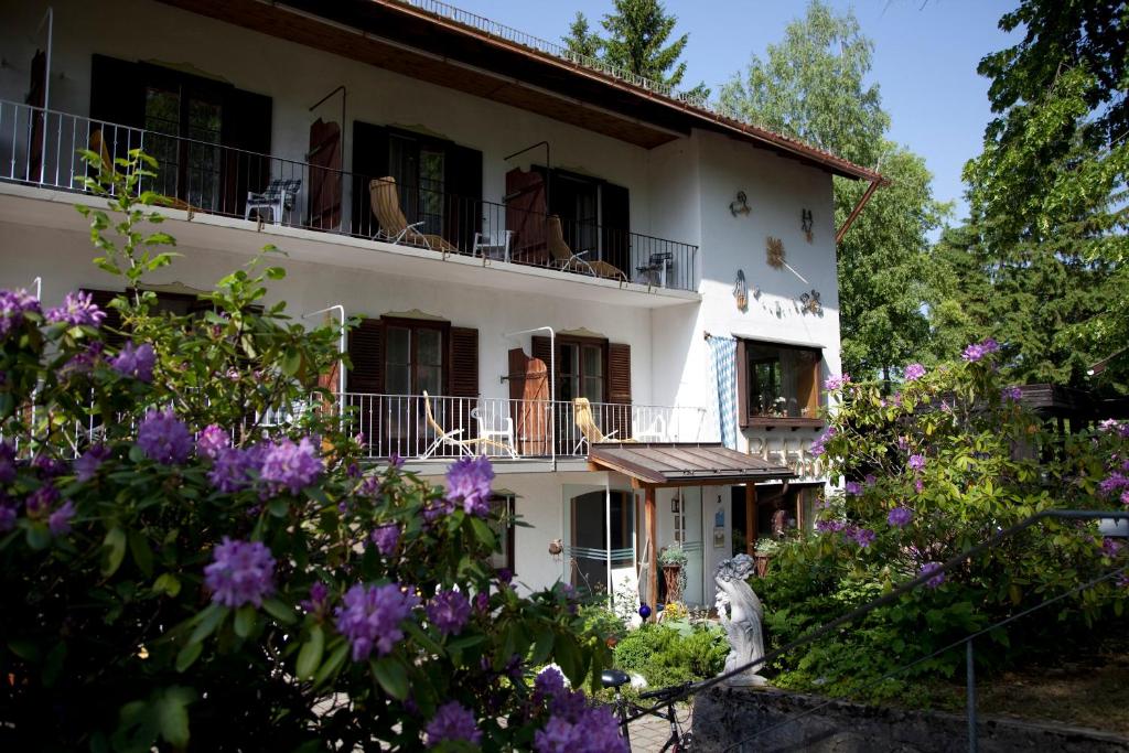 a white house with purple flowers in front of it at Haus BEER in Bad Tölz