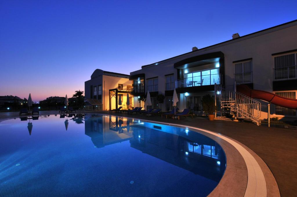 a swimming pool in front of a building with a water slide at Odyssey Residence Apartments in Fethiye