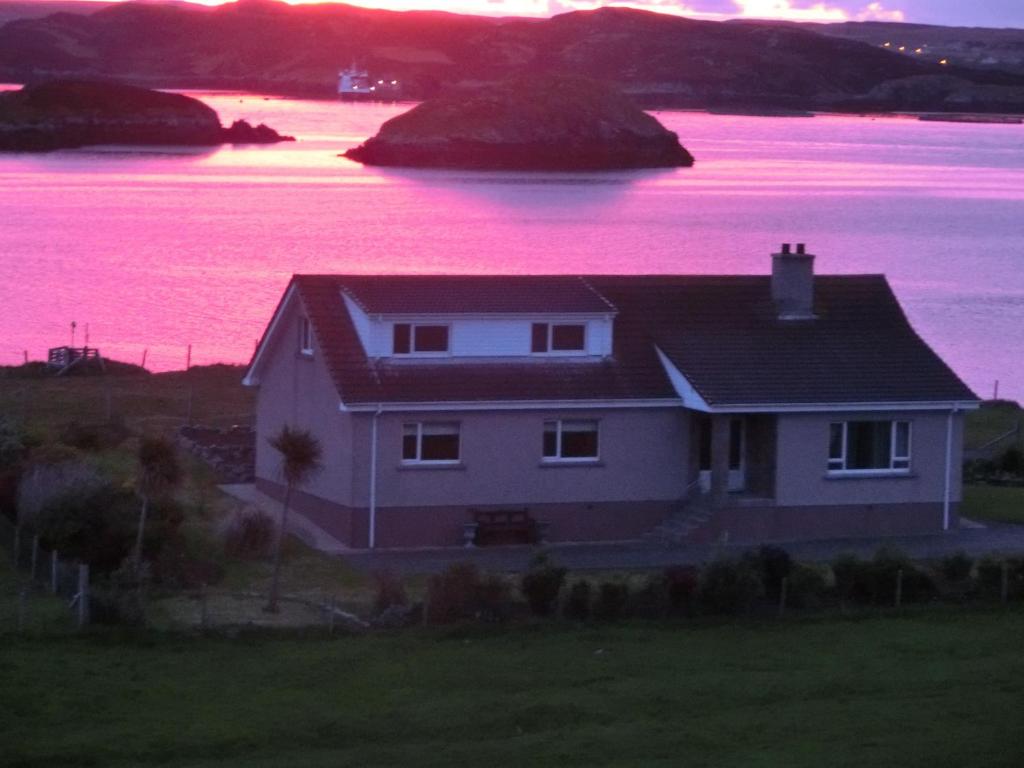 Hebridean Sea View Cottage في Cromore: منزل مطل على جسم ماء